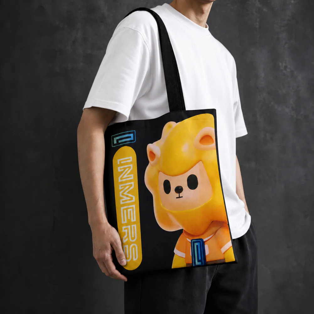 Person carrying a black INMERS tote bag featuring the mascot