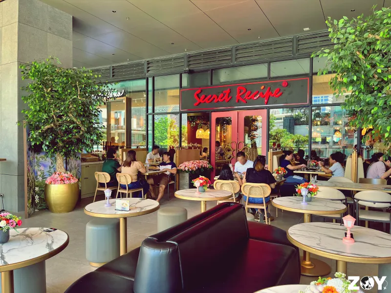 Alfresco seating outside Secret Recipe at One Ayala Level 2 with diners at marble tables